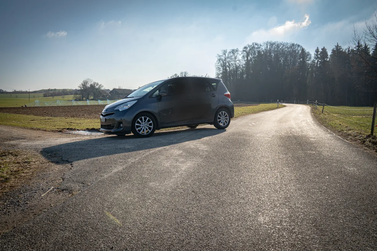 Ein Auto steht auf einer Landstrasse.